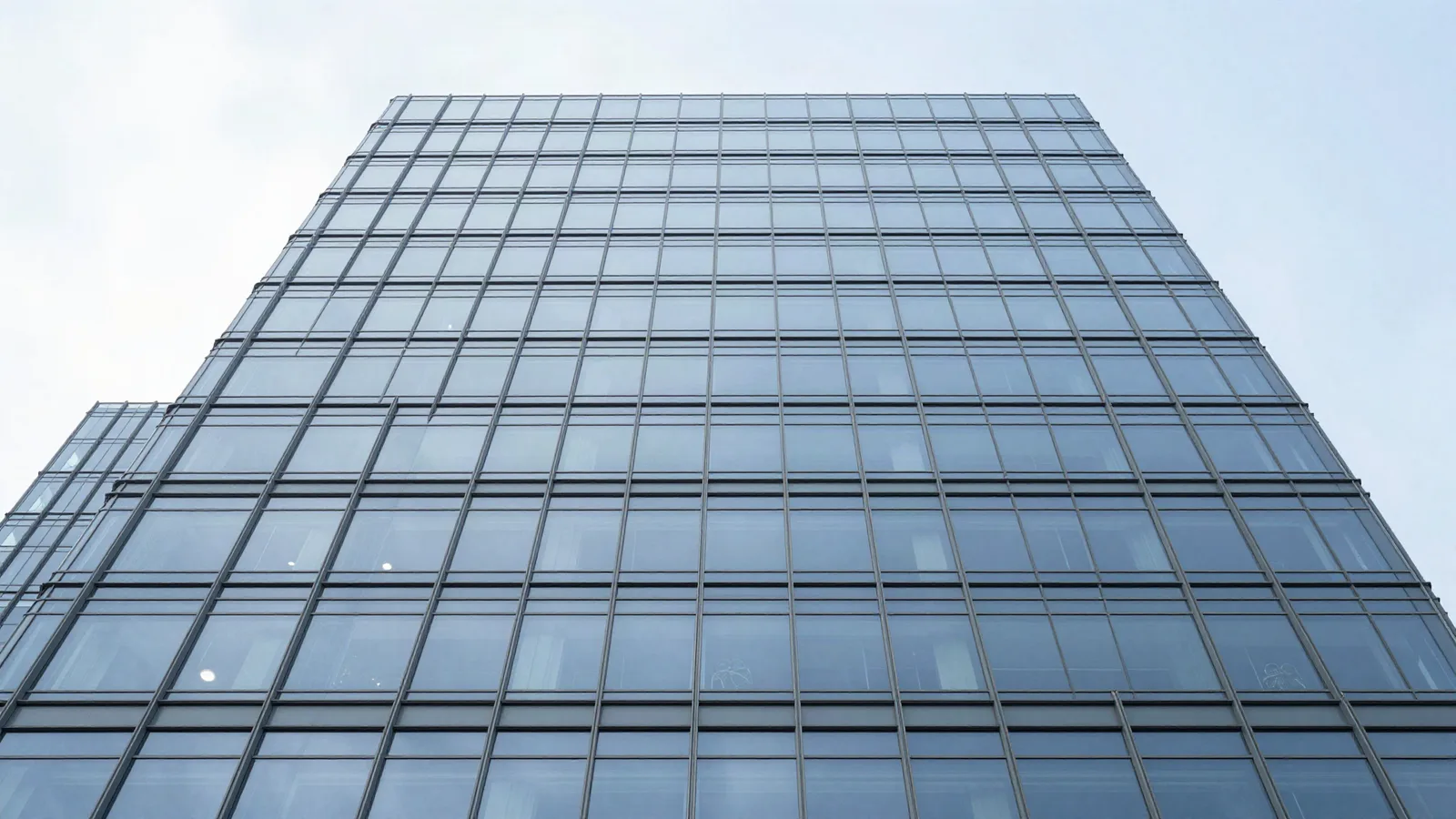 Tour de bureaux vitrée vue en contre-plongée — actif pour lequel un investisseur étranger exige une expertise aux normes RICS