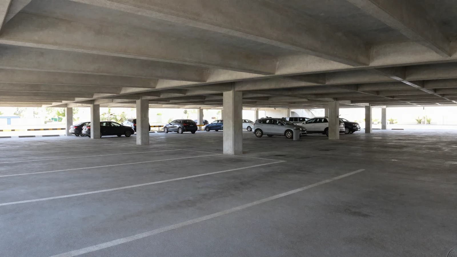 Parc de stationnement couvert avec places matérialisées et rampes — évaluer une place ou un box en copropriété