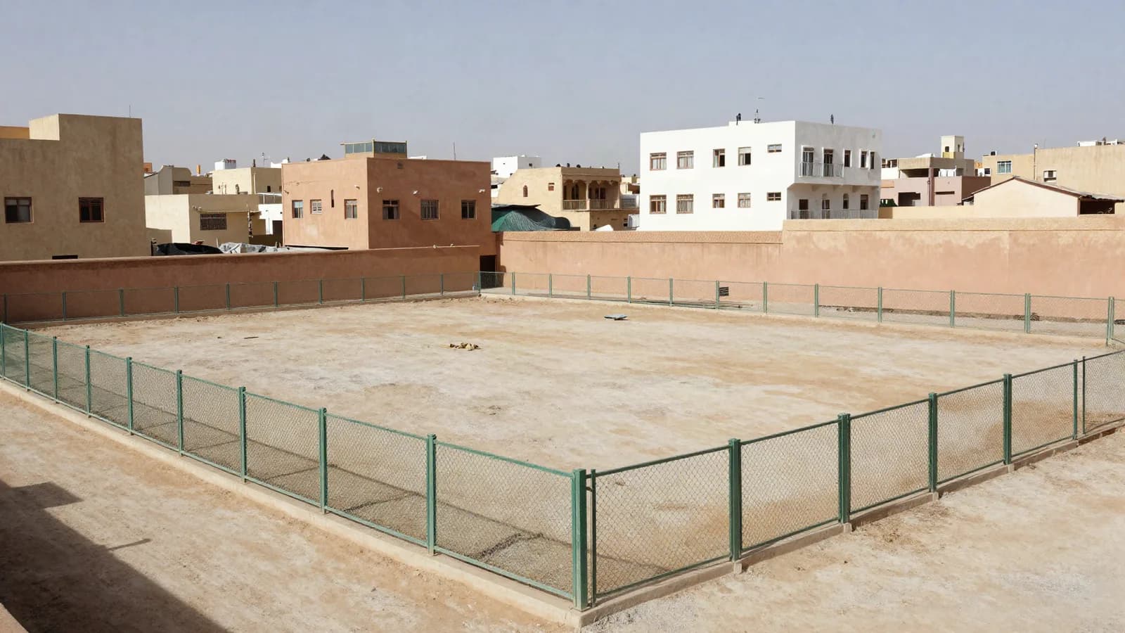 Terrain à bâtir clôturé et totalement intact au milieu d'immeubles achevés — permis de construire refusé
