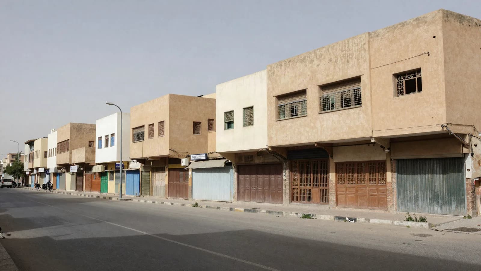 Avenue où une rangée de constructions basses s'interrompt net contre un immeuble récent — effets d'un plan d'aménagement