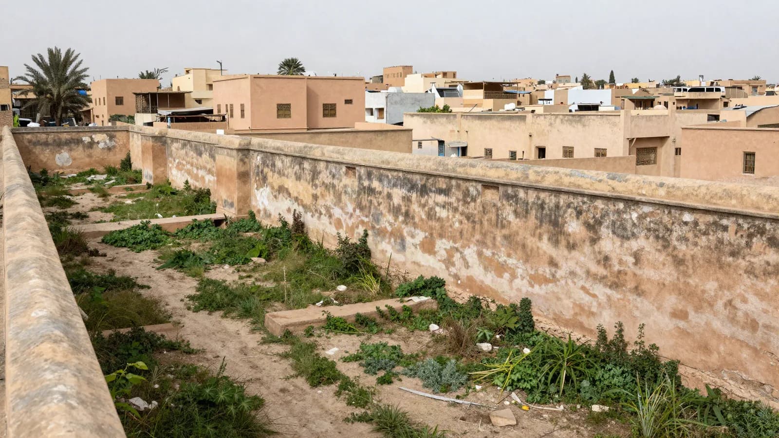 Parcelle murée laissée en friche depuis des années au cœur d'un quartier bâti — terrain gelé par un plan périmé