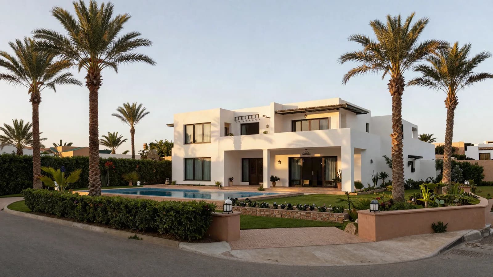 Villa contemporaine à jardin clos, palmiers et piscine, vue depuis l'allée — expertise d'une villa de haut standing